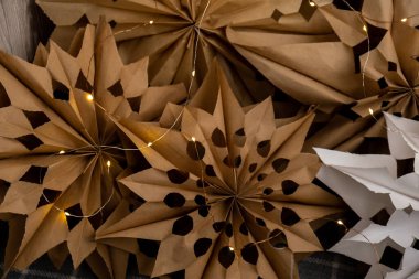 3d craft snowflakes with garland lights. Master class of making craft paper snowflakes for conscientious Christmas decor. Sustainable celebration minimal responsible DIY holiday project. Step by step