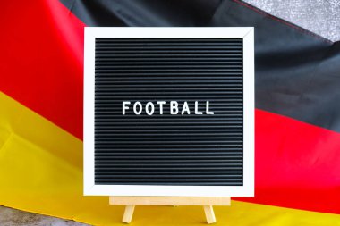 Almanya 'nın FOOTBAL Ulusal Sembolü yazılı mektup panosu. Alman dalgalı ipeksi bayrak arka planı. Spor futbolu kavramı ve milli takım ligini destekleme