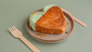 Lezzetli ve canlı kalp şeklinde kruvasan şekerli tabak. Renkli fındıklı kruvasanla güzelce kaplanmış. Şablon kopyalama alanı oluşturun. Gıda deneyleri viral tatlı yaratıcı