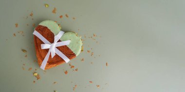 Hediye kurdelesi lezzetli taze kruvasan üstüne de Matcha Green Tea aromalı Ganache. Eşsiz kalp şekilli fırın. Puff pasta bayramı aşk sembolü fikri Sevgililer Günü. Boşluğu kopyala 