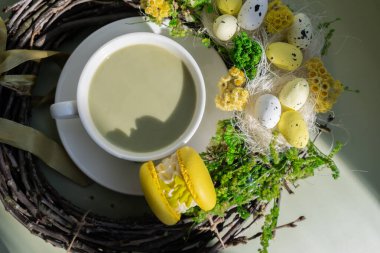 Sarı badem kurabiyeli yeşil latte kibriti ve EASTER sürdürülebilir dekorasyonu. Tatil kahvaltısı çay içeceği kavramı. Sıcacık minimalist süper yiyecekler canlı renkler sağlıklı beslenme. Organik