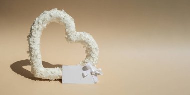 Reklam şablonu için boş beyaz alan. Aşkın sembolü. Bej arka planda kalp şeklinde güzel çiçek yaprakları. Sevgililer Günü 'nün yaratıcı konsepti, romantik bir tarih ya da yıldönümü.