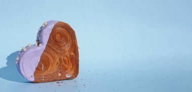 Sevgililer Günü bayramı hediyesi fikri. Lezzetli ve canlı kalp şeklinde kruvasan ikramı. Renkli kremayla kaplanmış. Uzayı kopyala Gıda deneyleri viral