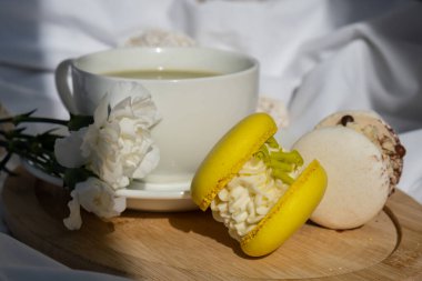 Besin zengini kibritçi içeceği. Yatakta ahşap tepside taze çiçeklerle modadan yapılmış makarna tatlısı. Günaydın güzel kahvaltı hediyesi fikri. Canlı yaratıcı renkler. Doğal enerji çay verir.