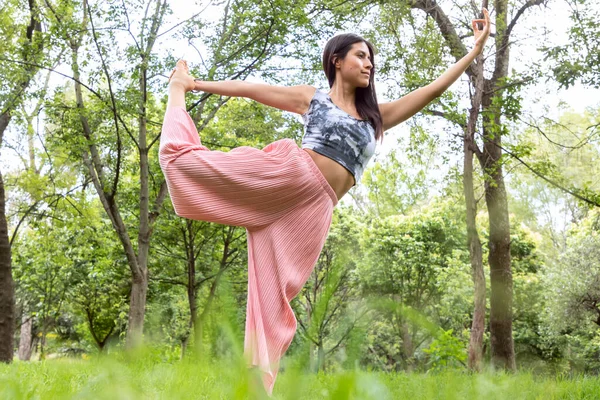 Latin kadın Yoga-asana yapıyor, farklı duruşlarla, arka planda çimenler ve ağaçlarla parklarda.