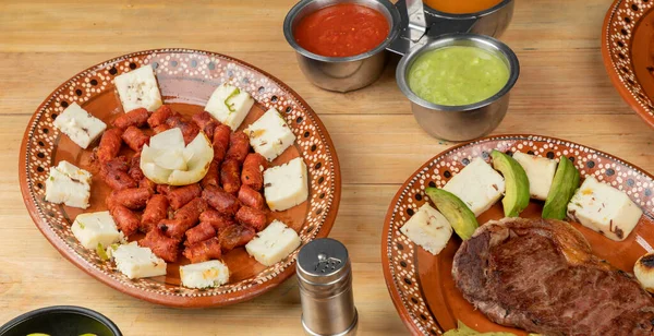 Chistorra schotel met kaas gemonteerd op een klei plaat vergezeld van saus. Mexicaans eten — Stockfoto