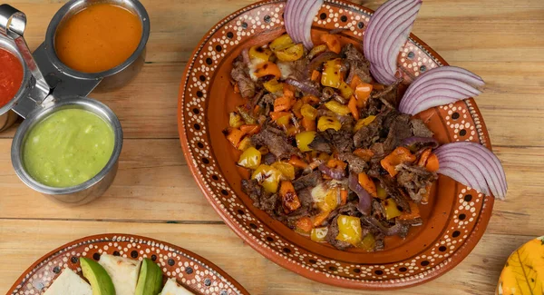 Mexicaans eten, vleesdraad geserveerd op een bord met ui op een houten tafel — Stockfoto