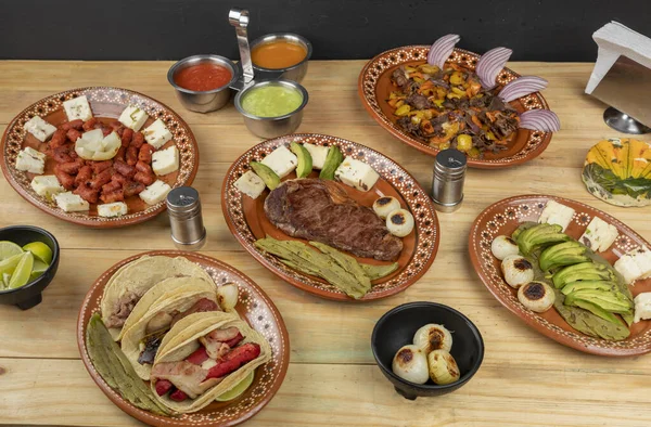 Mexicaans eten geserveerd in klei gerechten, op een houten tafel — Stockfoto