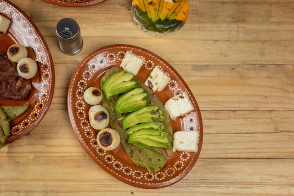 Mexicaans eten. orde van avocado met nopal en ui geserveerd in een aardewerk plaat op een houten tafel — Stockfoto