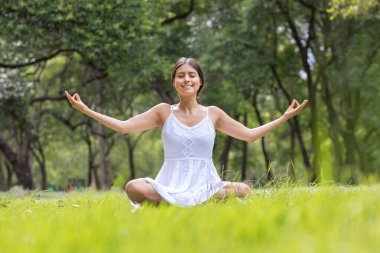 Nilüfer çiçekli Meksikalı kadın parkta meditasyon yapıyor. 