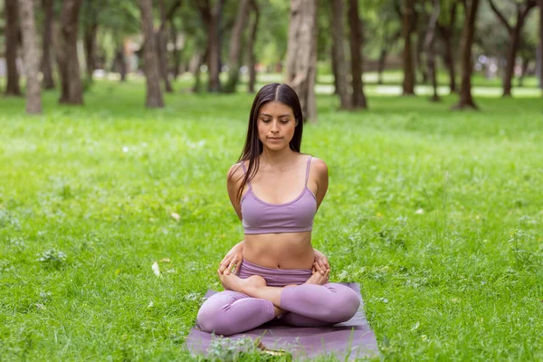 Mujer haciendo yoga posa sobre hierba verde en parque —  Fotos de Stock