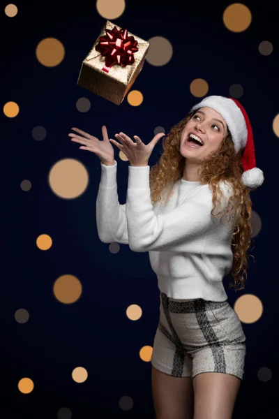 Genç Latin kadın gülümsüyor, Noel 'i kutlarken hediye yakalıyor. Metin için boşluk