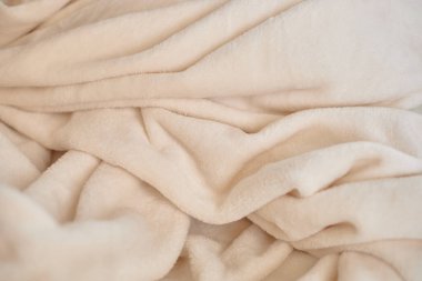 Yumuşak bej kumaş dokusu nazik kıvrımlar sergiler, rahat ve davetkar bir atmosfer yaratır, ev dekorasyonu ve tekstil tasarımı için mükemmeldir.