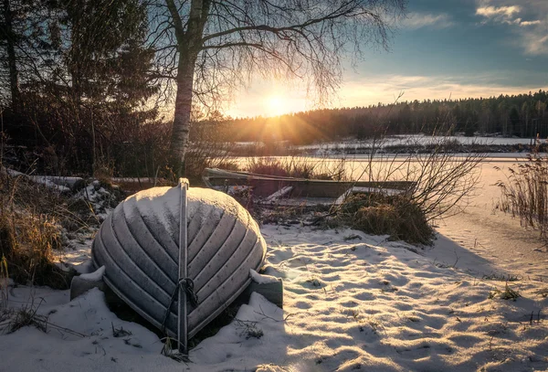 Télen napnyugtakor a befagyott tavon hajók — Stock Fotó