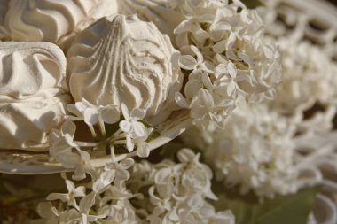 Yumuşak ve tatlı marşmelovlar ve bağbozumu masasında beyaz leylak çiçekleri ışıl ışıl bahar havası yaratır