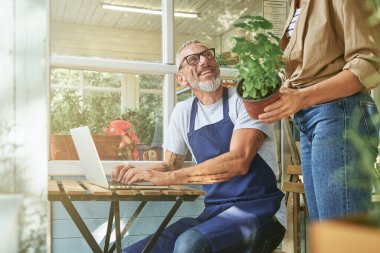 Mutlu orta yaşlı beyaz adam ve kadın çalışıyor.