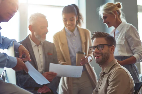 Reunión de negocios. Grupo de empresarios multirraciales analizando informes, discutiendo los resultados del proyecto mientras trabajan juntos en la oficina moderna — Foto de Stock