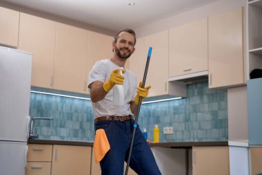 Young caucasian man spraying detergent at camera