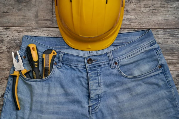 Protective helmet and tools in jeans pocket