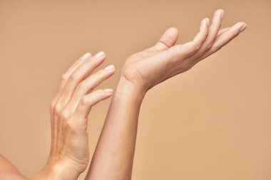 Spa tedavisi. Güzel kadın elleri bej arka planda izole edilmiş.