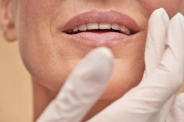 Cosmetólogo revisando la piel de la cara femenina antes de la terapia médica — Foto de Stock