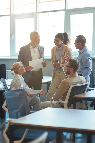 Foto vertical de gente de negocios multirracial alegre teniendo una reunión en la oficina moderna, discutiendo el trabajo y sonriendo —  Fotos de Stock