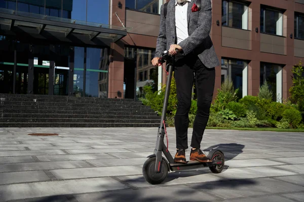 Öko-Fahrzeug. Schnappschuss eines eleganten, eleganten Geschäftsmannes mittleren Alters, der tagsüber mit seinem Elektroroller auf der städtischen Straße unterwegs ist — Stockfoto