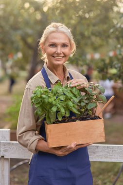 Bahçede çalışan orta yaşlı beyaz iş kadını.
