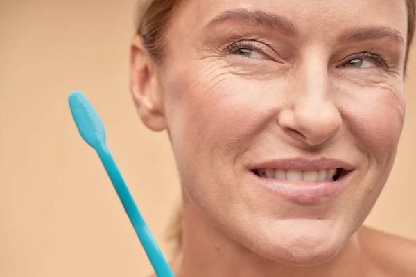 Sonriente mujer madura va a cepillarse los dientes — Foto de Stock