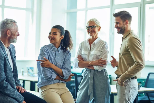 Équipe d'affaires multiraciale réussie debout dans le bureau moderne, communiquer et discuter de quelque chose — Photo