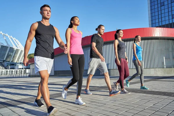 Young sport team walking in line along paved area