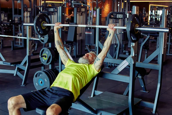 Ασκήσεις βαρέων βαρών. Σπρώχνω τα όρια του ανθρώπινου σώματος. Ισχυρός ώριμος καυκάσιος άνδρας ανύψωσης βαρέος μπαρ ή βαρελιού στο γυμναστήριο — Φωτογραφία Αρχείου