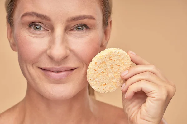 Mujer bonita quitando maquillaje con una esponja — Foto de Stock
