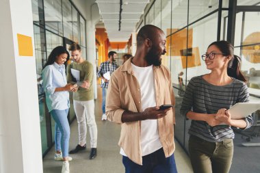 Heyecanlı meslektaşlar iş yerine yürüyor ve hikayelerini paylaşıyor.