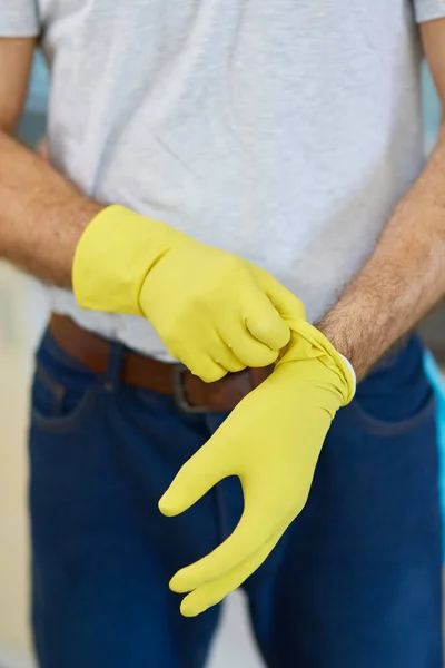 Allez-y. Gros plan des mains de l'homme, nettoyeur professionnel masculin portant des gants tout en se préparant pour faire les travaux ménagers — Photo