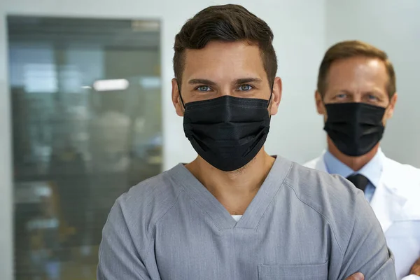 Dos doctores con mascarillas mirando a la cámara — Foto de Stock