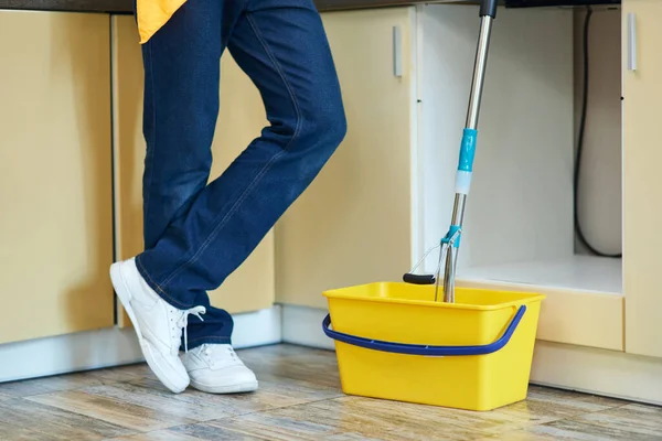 Sağdan temizlendi. Profesyonel erkek temizlikçi, paspasla kovanın yanında duruyor. Evde yerleri temizlemeye hazır. — Stok fotoğraf