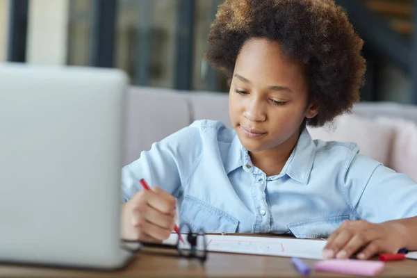 Lebih banyak waktu untuk seni. Ras campuran remaja gadis sekolah menggambar di atas kertas dengan penanda warna-warni saat belajar dengan laptop di rumah selama karantina — Stok Foto