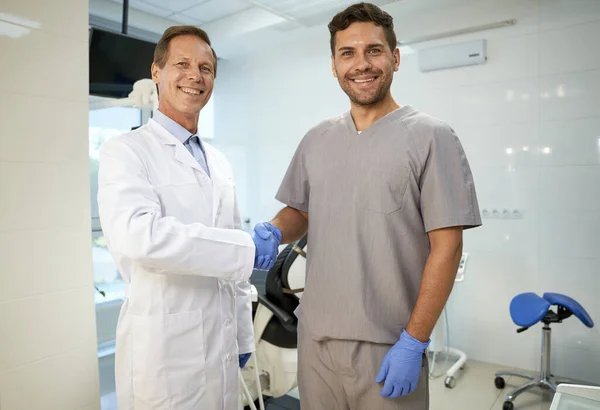 Diş kliniğinde el sıkışan iki erkek arkadaş. — Stok fotoğraf