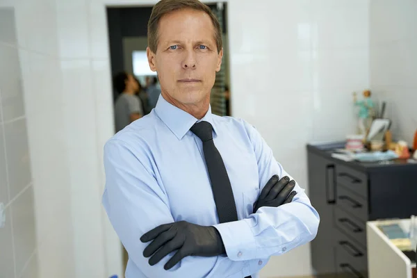 Hombre serio de mediana edad con guantes cruzados —  Fotos de Stock