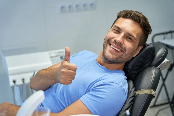 Contented patient of dental clinic showing thumbs up — Stock Photo, Image