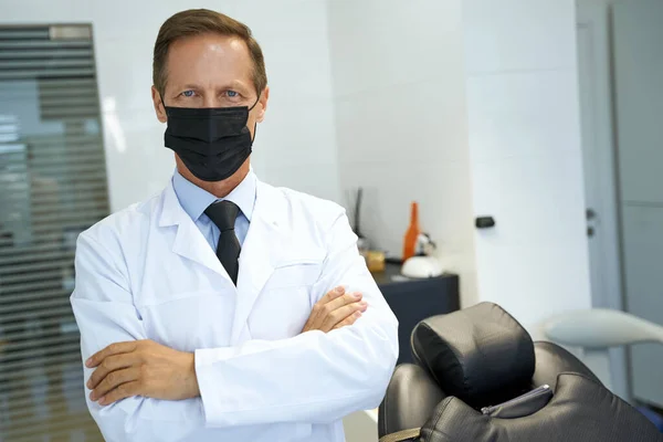 Kvalificerad tandläkare poserar medan du bär mask — Stockfoto