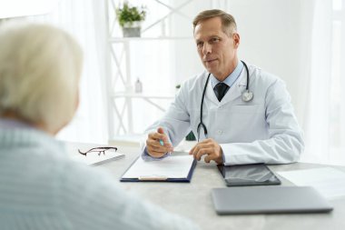 Yakışıklı erkek doktor, klinikte hastasıyla randevusu var.