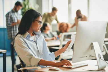 Sorumlu esmer kadın bürodaki verileri kontrol ediyor.