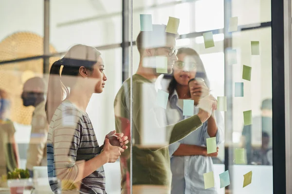 Drei Kollegen diskutieren hinter Glaswand — Stockfoto