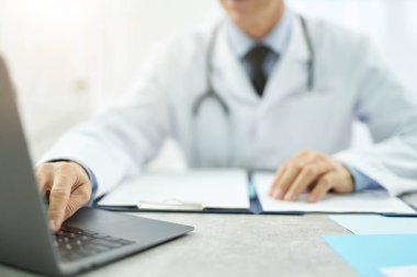 Klinikte modern laptop kullanan erkek doktor elleri.