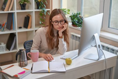 Evde bilgisayar başında çalışan genç bir kız öğrenci.