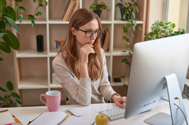 Karantina sırasında bilgisayar başında çalışan ciddi bir kadın.