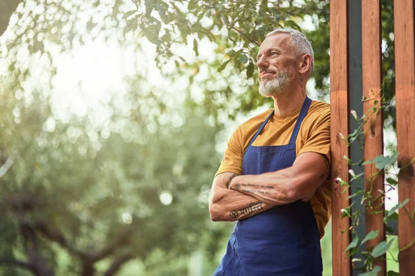 Middle aged caucasian farmer standing near fence