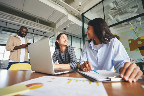 Deux jeunes femmes heureuses assises au bureau ensemble — Photo